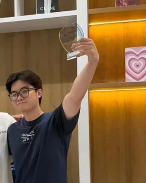 Đức raising a glass trophy at Savyu's hackathon.