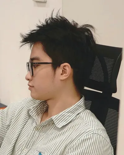 Hoàng Huy Đức in profile, seated in an office chair.
